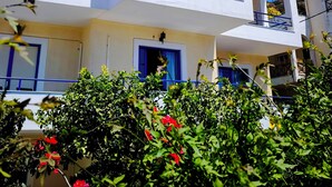 A multi-story building with balconies and a sign reading "PERLIA STUDIOS". - Valente Perlia Rooms (Poros)
