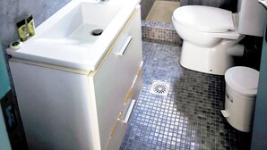 A bathroom with a white sink, toilet, and shower area. - Valente Perlia Rooms (Poros)