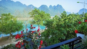 A view of a coastal area with mountains in the background, a beach, and some greenery. - Phong Nha Homie Home (Phong Nha)