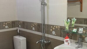 A bathroom with a toilet, a shower, and a sink. - Phong Nha Homie Home (Phong Nha)