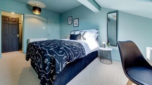 A bedroom with a bed, a chair, a small table, and a mirror. - The Rockfield By Serene Stays (Anfield)