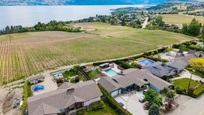 Un quartiere residenziale con case, una piscina e un vigneto.