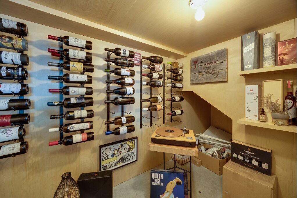 A wine cellar with multiple wine racks, a record player, and various wine bottles.