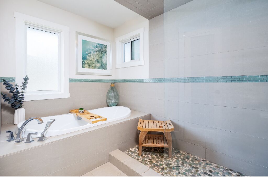 A bathroom with a bathtub, a sink, and a small wooden stool.