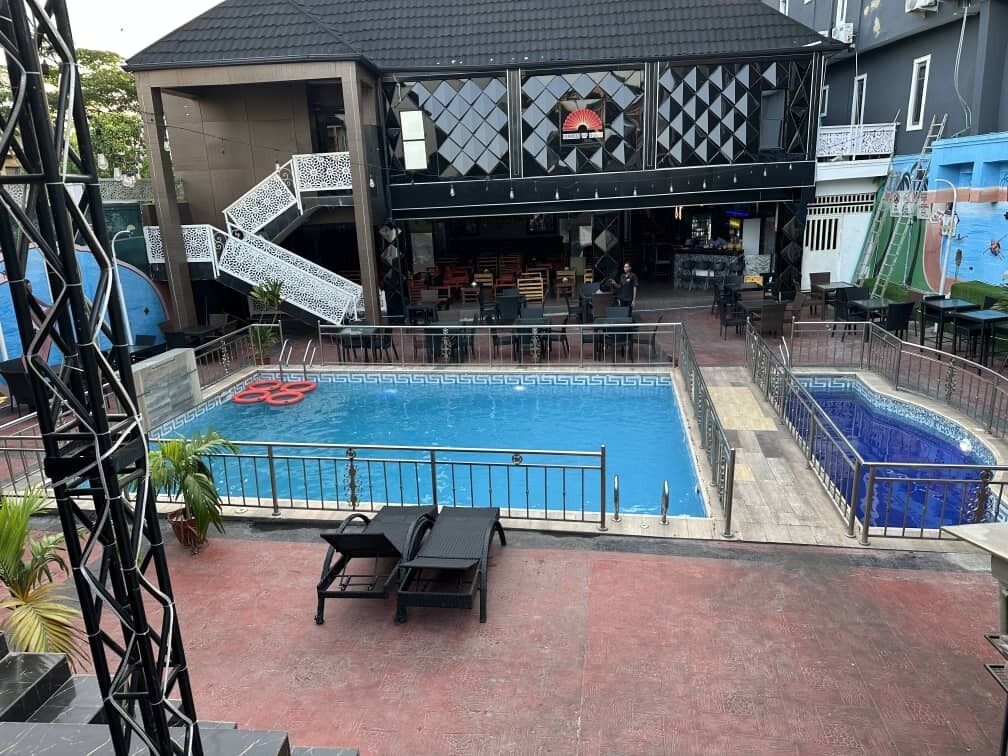 Un área de piscina con dos piscinas separadas, zona de bar y asientos al aire libre.