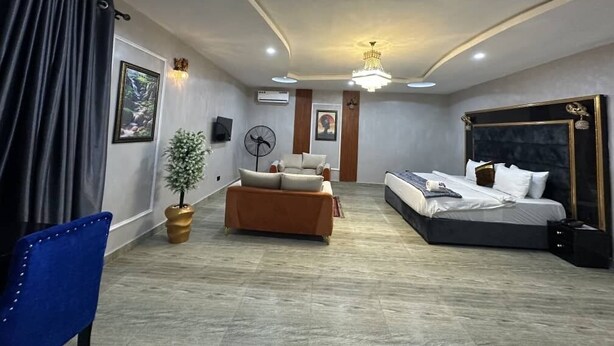 A modern hotel room with a bed, sofa, and a chair. - mountaintop suite and apartment (Lagos)