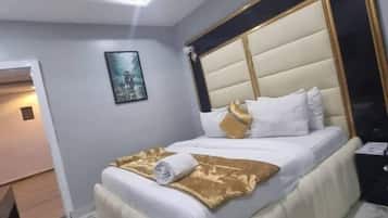 Un dormitorio moderno con una cama grande, un cabecero y una mesita de noche.