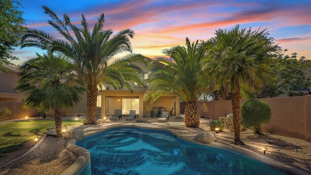 A swimming pool with palm trees, a covered patio, and a sunset view. - Prime Glendale Location 8-Mins From Westgate Entertainment! (Glendale)