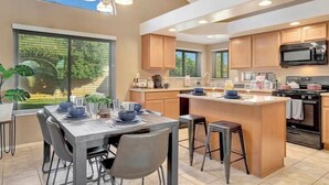 A modern kitchen with a large island, wooden cabinets, and a built-in microwave. - Prime Glendale Location 8-Mins From Westgate Entertainment! (Glendale)
