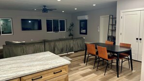 A modern kitchen with a marble countertop, wooden cabinets, and a dining area with a table and chairs. - Scenic lakeside retreat- 5 minute walk to Palisade State Park and Golf Course (Sterling)