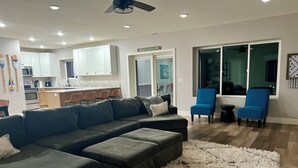 A modern living room with a sectional sofa, a fluffy rug, and a dining area with chairs. - Scenic lakeside retreat- 5 minute walk to Palisade State Park and Golf Course (Sterling)