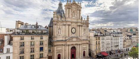 A historic church with a prominent clock tower, surrounded by classic European architecture.