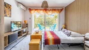 A modern bedroom with a bed, a TV, a desk, and a view of the outdoors. - Modern Studio - AC - 2P - Cannes (Cannes)