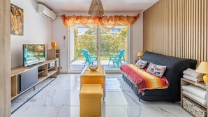 A modern living room with a sofa, TV, and a dining area. - Modern Studio - AC - 2P - Cannes (Cannes)