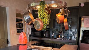 A kitchen with a central island, stainless steel appliances, and a hanging pot rack. - Miami Wellness Sanctuary w/ Sauna, Cold Plunge & Hot Tub (Miami)
