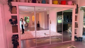 A room with a sliding glass door leading to a kitchen area. There are yoga mats and a small rug on the floor. - Miami Wellness Sanctuary w/ Sauna, Cold Plunge & Hot Tub (Miami)