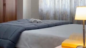 Un dormitorio con cama, armario de madera y pared con persianas verticales.