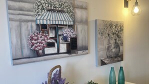 A white console table with wicker baskets containing flowers and a small plant, flanked by two teal vases. - Entire apartment with terrace, free parking, free wi-fi (Vico Equense)
