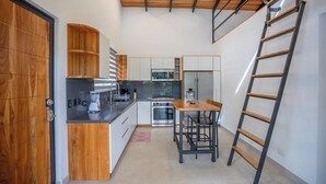 Une cuisine compacte dotée de meubles en bois, d’un îlot central et d’un four encastré.