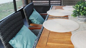 A wicker dining area with a wooden table, woven placemats, and a potted plant. - Orlando 3 Bedroom Close to Disney (Orlando)