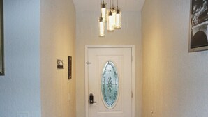 A hallway with a white door featuring a stained glass design, a sign above it, and a light fixture above the door. - Orlando 3 Bedroom Close to Disney (Orlando)