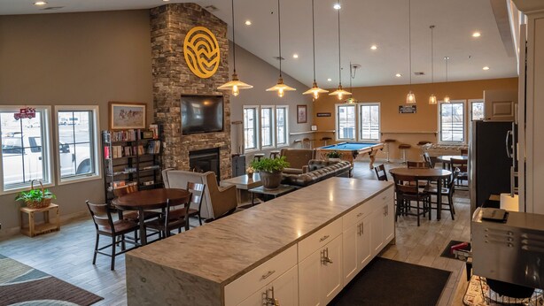 Una cocina amplia con una isla grande, detalles de piedra e iluminación moderna.