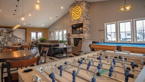 Amplio espacio interior con mesa de futbolín, mesa de billar y chimenea.