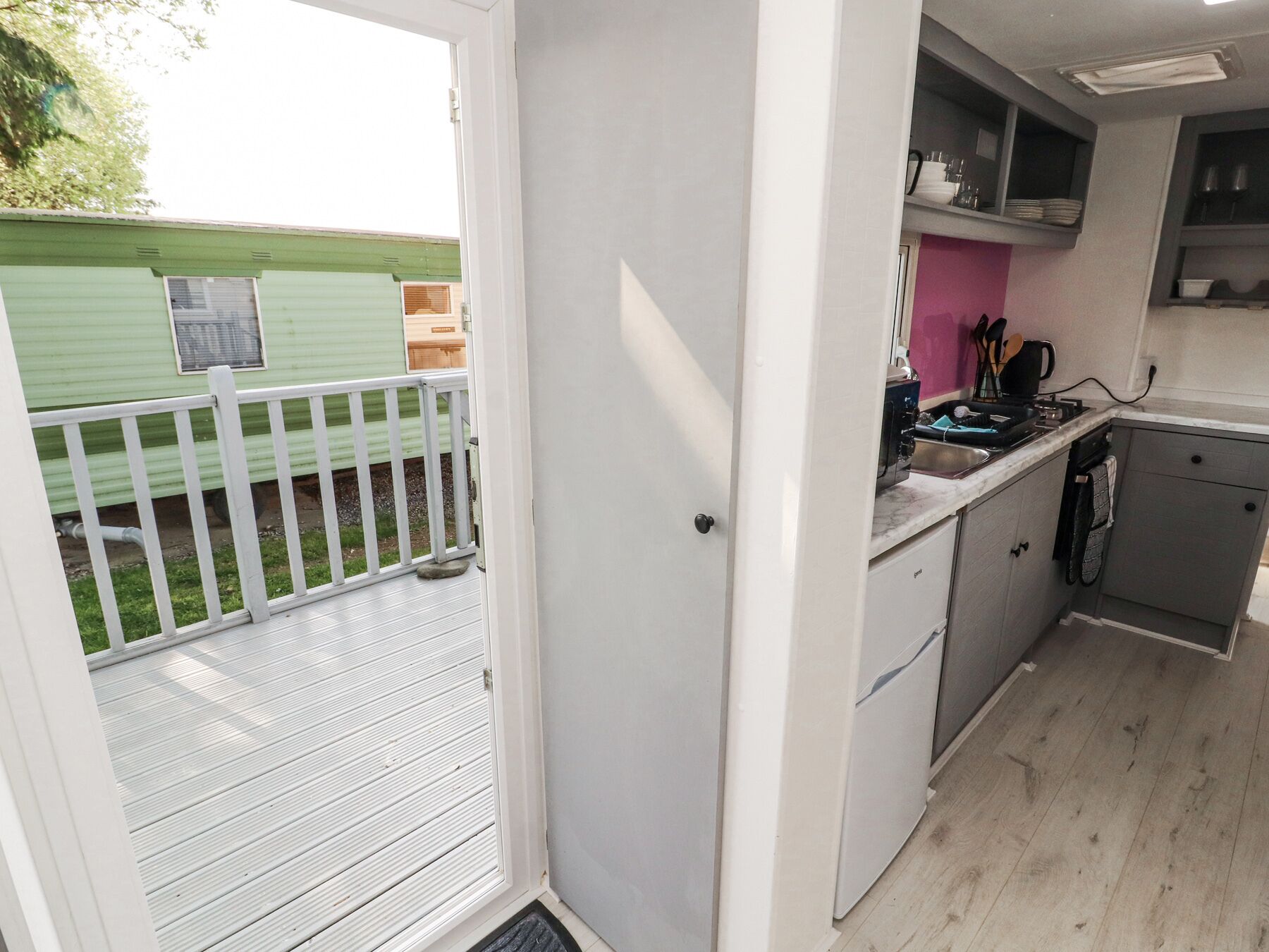 A compact kitchen with a sink, stove, and cabinets.