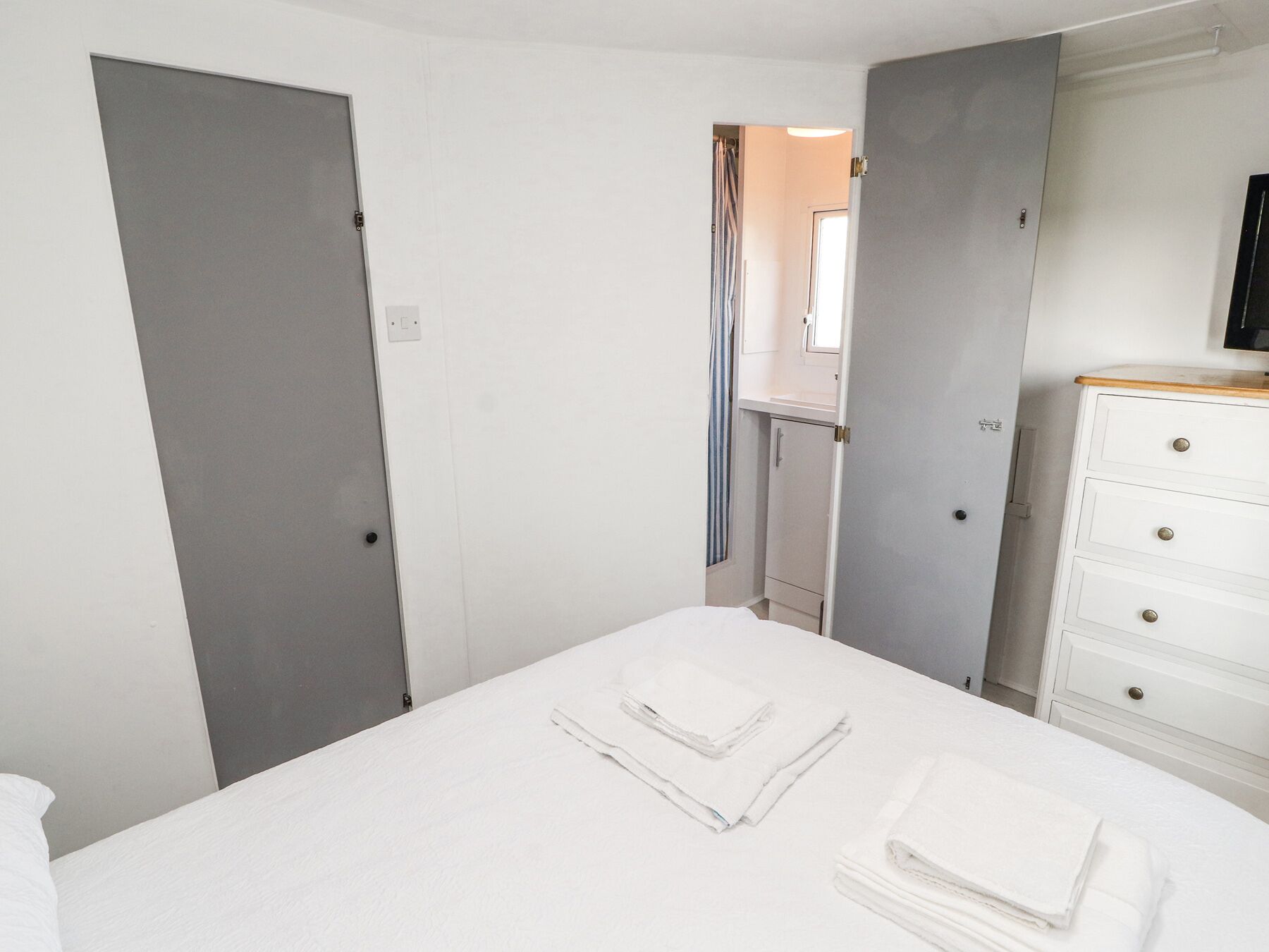 Ein Hotelzimmer mit Bett, Schminktisch und Duschbereich.