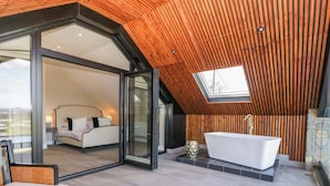 A modern bathroom with a freestanding bathtub and a skylight. - Forest Lodge (Pontyclun)