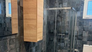 A modern bathroom with a glass-enclosed shower, a white toilet, and a beige sink. - Fast Latin Home (Seville)
