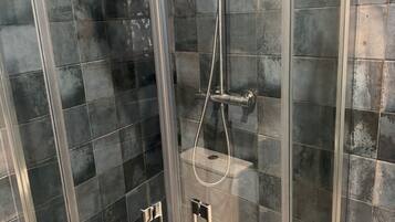 Een douche, handdoeken, zeep, shampoo