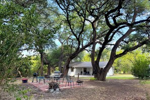 A patio area with a barbecue grill, outdoor furniture, and a large tree providing shade. - Jenkfarm Getaway
Your Home Away from Home (Nolanville)