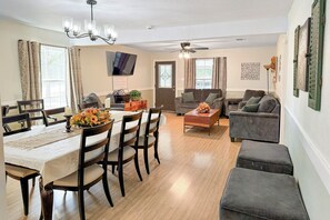 A dining area with a table set for four, a sofa, and a television mounted on the wall. - Jenkfarm Getaway
Your Home Away from Home (Nolanville)
