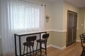 A room with a bar area, two chairs, a window with sheer curtains, a door, and a small potted plant on the wall. - Jenkfarm Getaway
Your Home Away from Home (Nolanville)