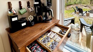 A coffee station with a coffee machine, tea dispensers, and a drawer with coffee pods. - Modern chalet 2 minutes from the Bras-du-Nord Valley | Spa & Sauna  (Saint-Raymond)