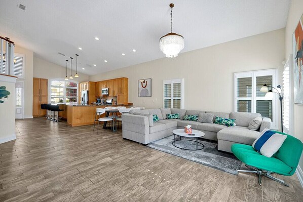 A spacious living area with a sofa, a coffee table, and a dining table with chairs.