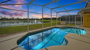 Ein Pool mit freiem Blick auf die umliegende Landschaft, ein überdachter Bereich mit Sitzgelegenheiten und eine großzügige Fensterkonstruktion.