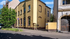 A yellow building with a brick base and multiple windows. - Apartment in Koblenz Near Deutsches Eck (Koblenz)