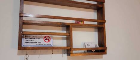 A wooden shelf with a sign indicating a penalty for smoking.