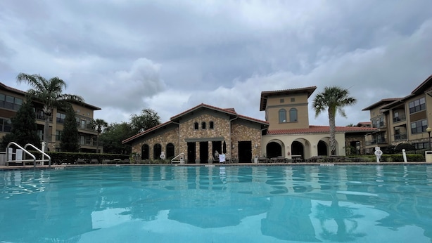 A swimming pool with a stone building in the background.