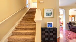 A carpeted staircase with a handrail, a framed artwork on the wall, and a black entertainment unit with a DVD player. - Disney 3BR Home, Pool, Lake View (Kissimmee)