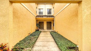 A narrow pathway leading to a building with a tiled roof and two doors. - Disney 3BR Home, Pool, Lake View (Kissimmee)