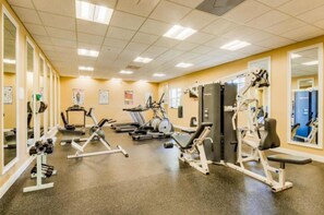 A gym with cardio machines, weight stations, and mirrors.