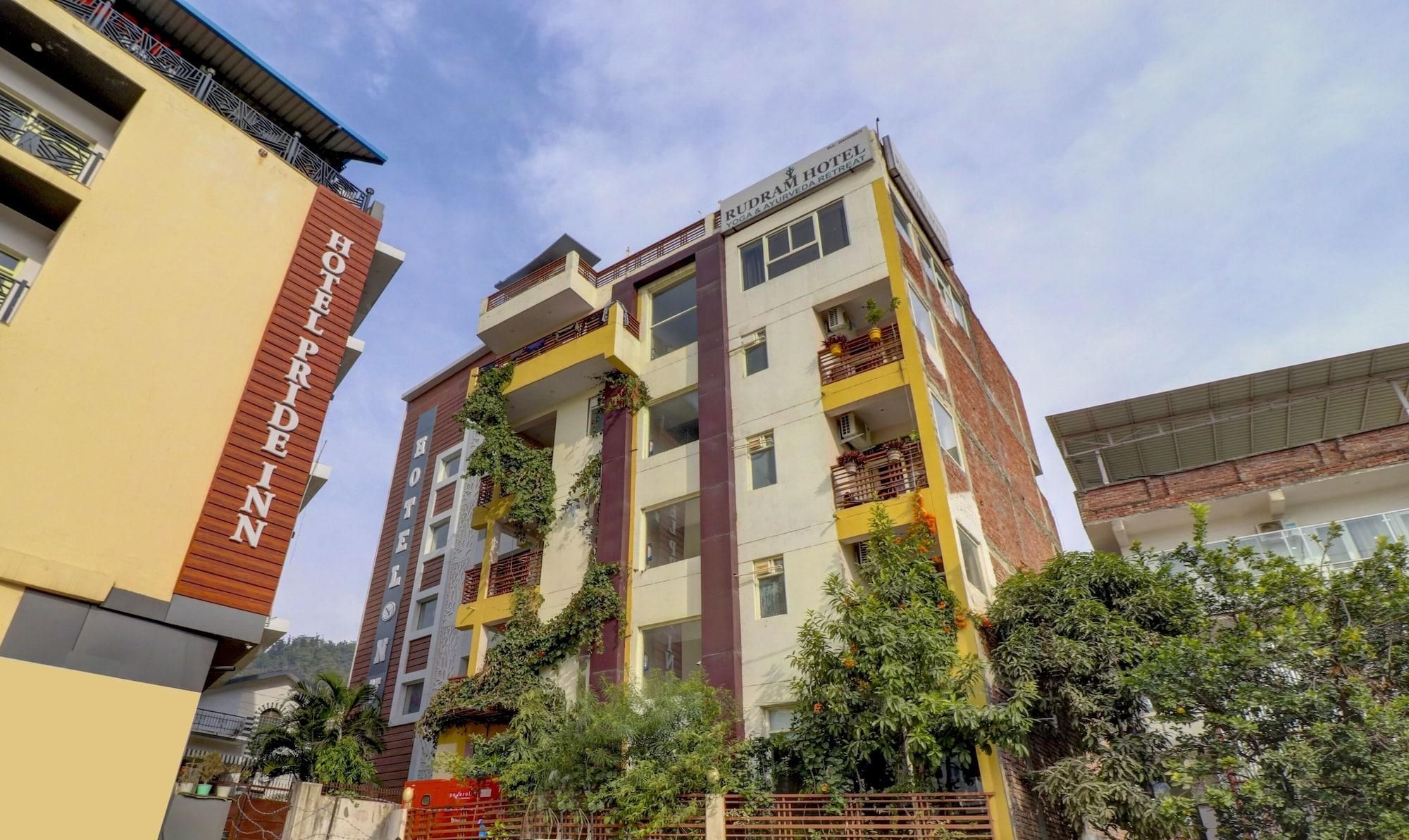 A multi-story hotel with a sign indicating it offers yoga and Ayurveda retreats.