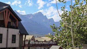 Une vue sur une montagne, avec un bâtiment de style chalet et un arbre au premier plan.