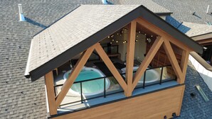 Il s’agit d’un bâtiment moderne, doté d’une façade en bois et d’une structure vitrée. À l’intérieur, on trouve une piscine et un espace détente agrémenté de guirlandes lumineuses.