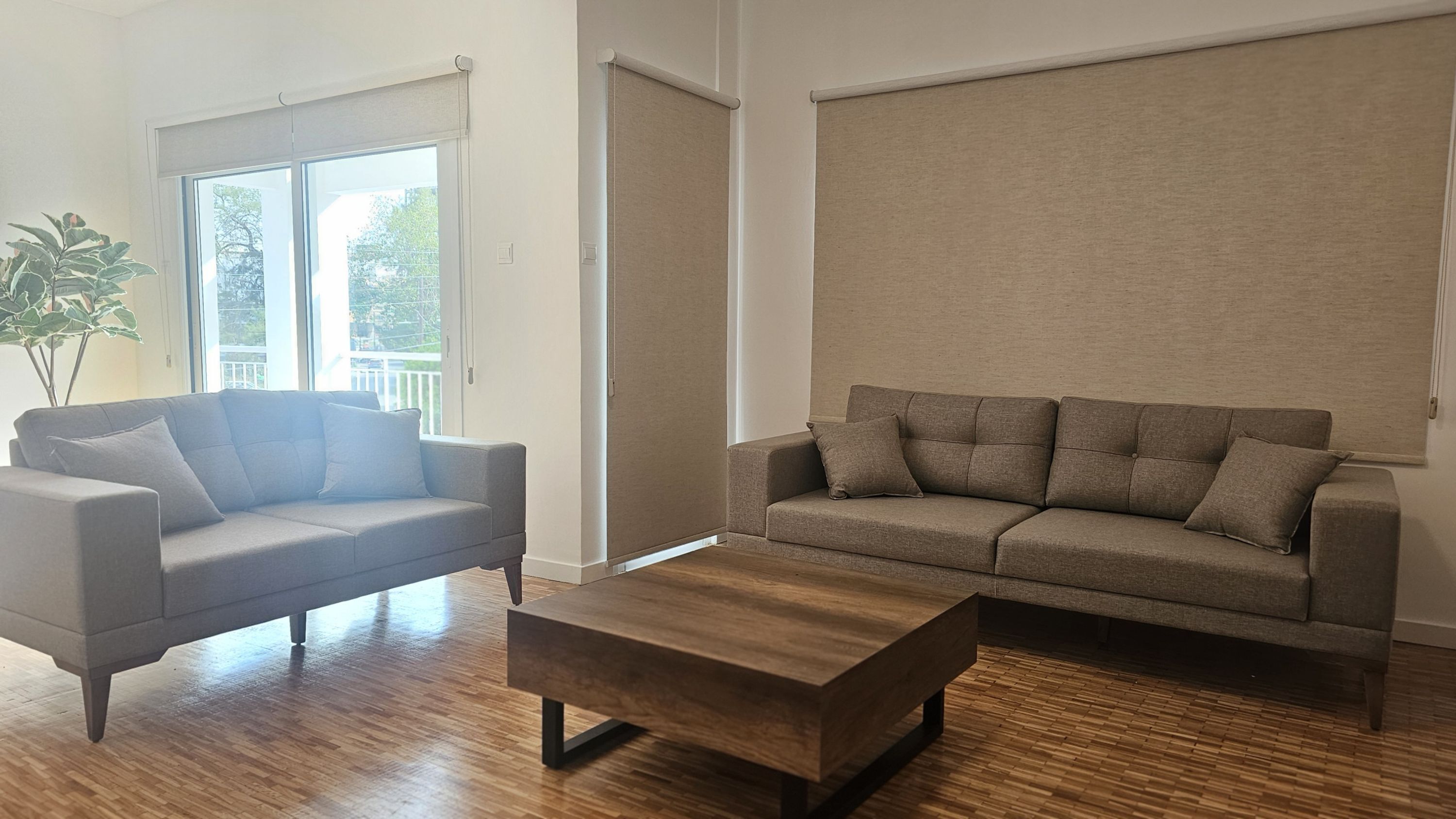 A living room with two sofas, a coffee table, and a sliding door.