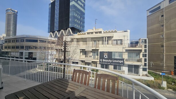 A view of a cityscape with modern buildings, including a Q Beauty Lounge. - 92 NIC - Stay Hydra Comfort Apartment (Nicosia)