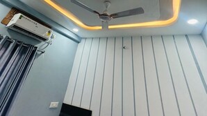 Un moderno soffitto con illuminazione a incasso e una ventola.